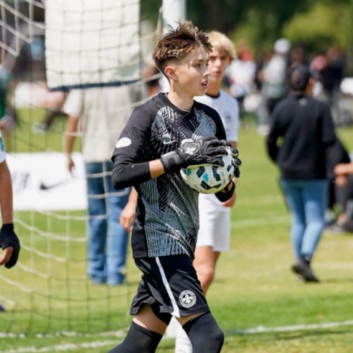 Young Goalkeeper wearing the Fleur de Lis Nova Pros 2.0 Onyx Trim Gloves.