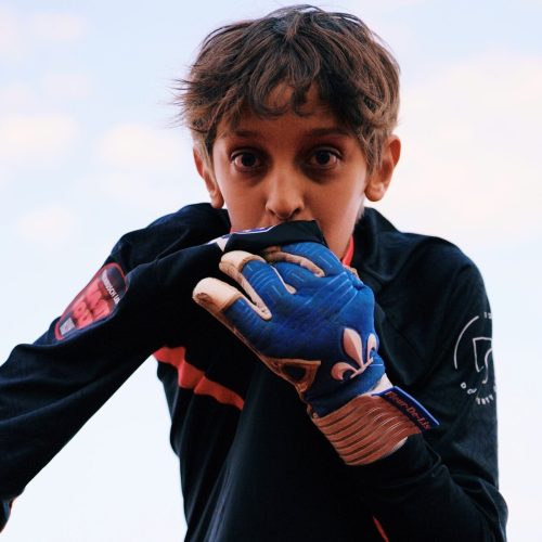 Goalkeeper kissing club kit while wearing Fleur De Lis GK Venum Pro Frost gloves.